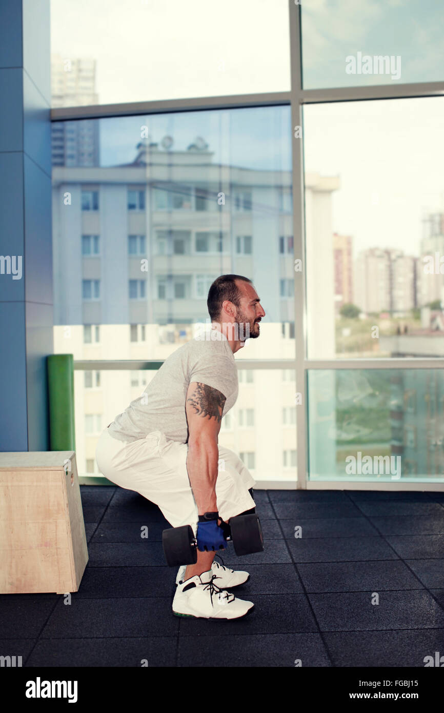 Uomo muscolare facendo esercizi in palestra Foto Stock