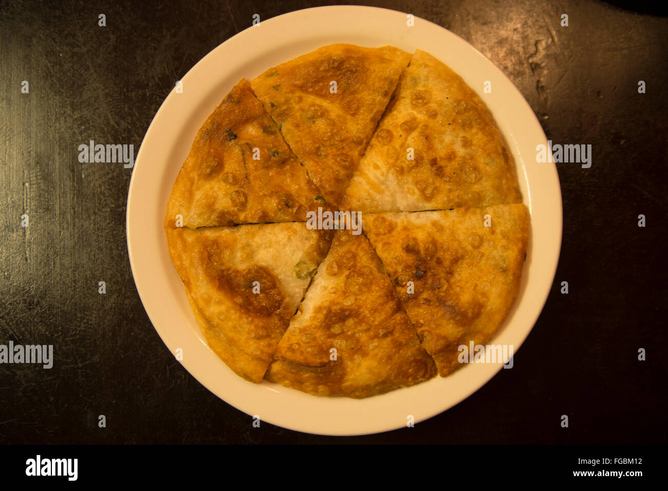 Cucina uigura: cipolla fatti a mano il pane appena sfornati e tagliato a pezzi Foto Stock
