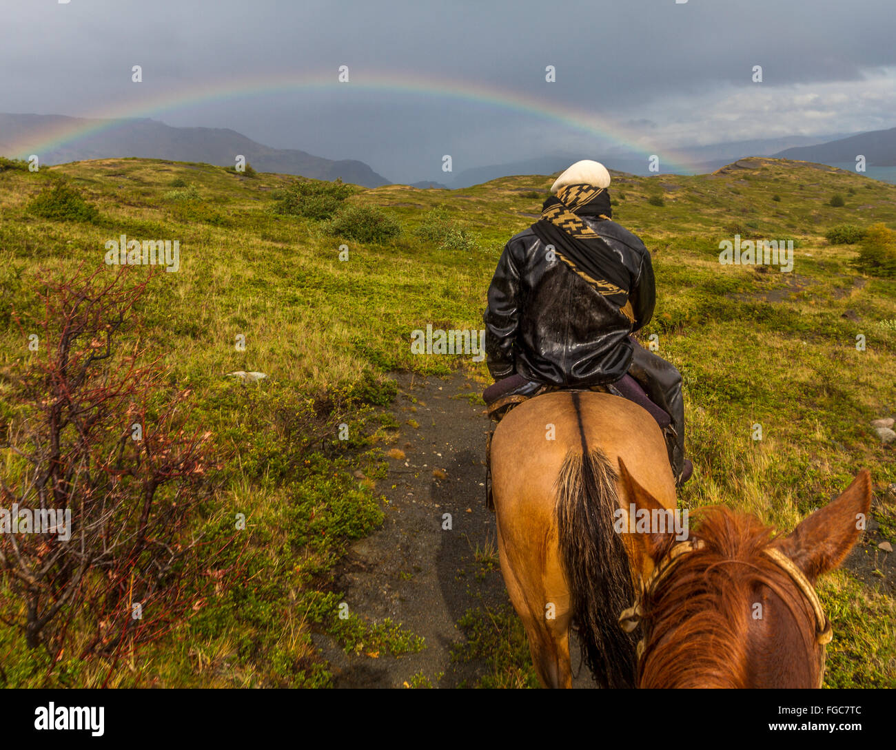Gaucho camminare verso un arcobaleno nel Parco Nazionale di Torres del Paine nella Patagonia cilena, Sud America Foto Stock