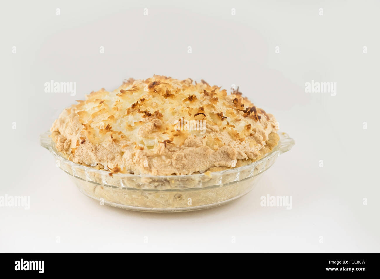 Un intero in casa pane appena sfornato cocco torta di meringa isolato su bianco. Foto Stock
