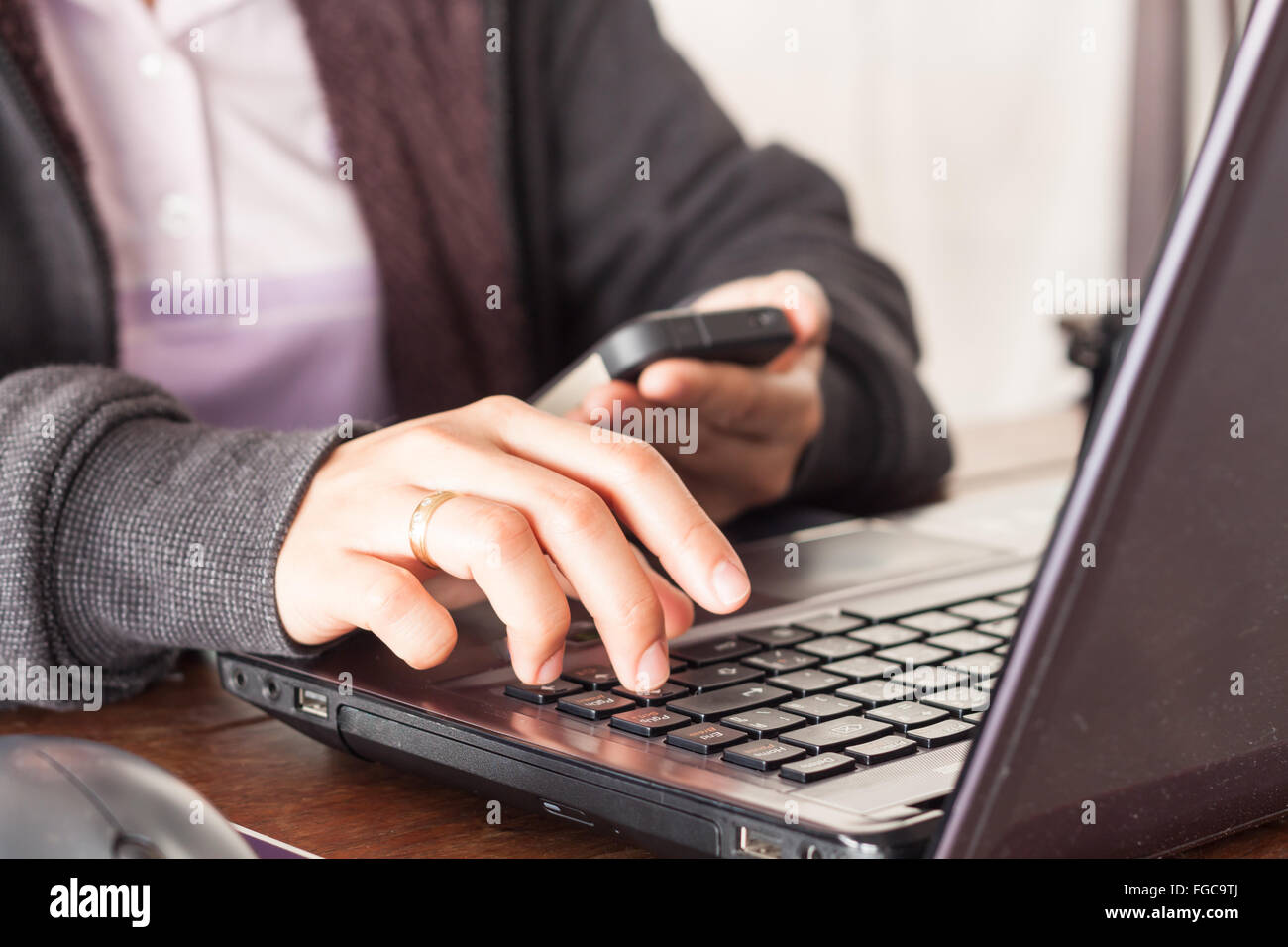 Donna che utilizza smart phone a scrivania da ufficio, stock photo Foto Stock