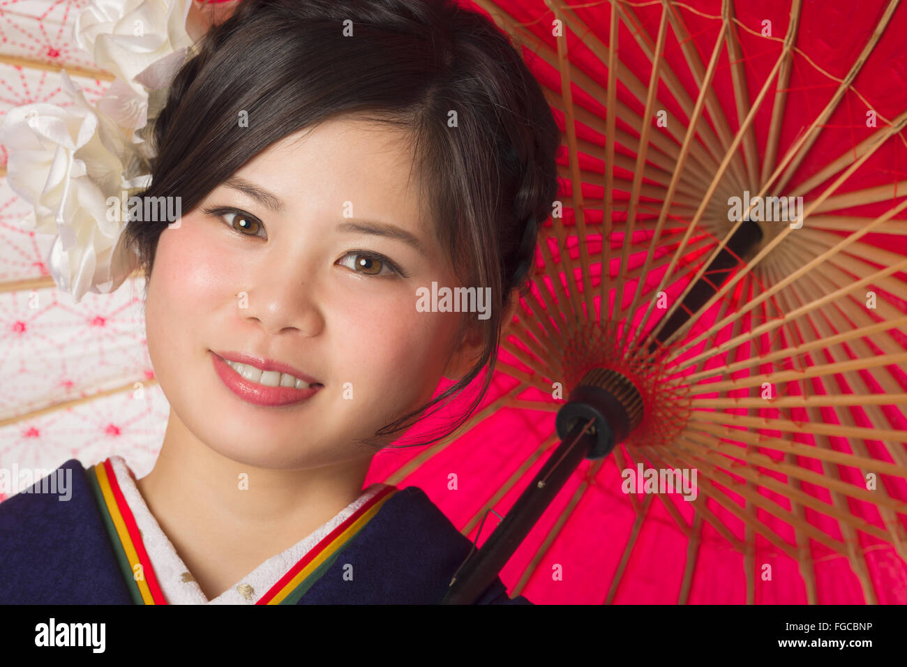 Un ritratto di una giovane e bella ragazza giapponese in un kimono blu per la sua venuta di età cerimonia il suo ventesimo compleanno. Foto Stock