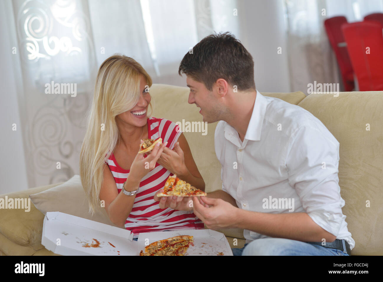 Giovane a casa a mangiare la pizza Foto Stock