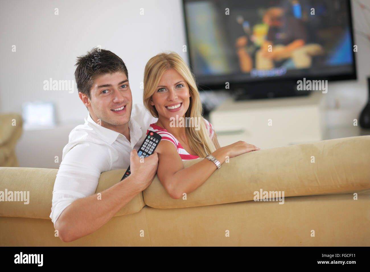 Rilassata coppia giovane guardando la tv a casa Foto Stock