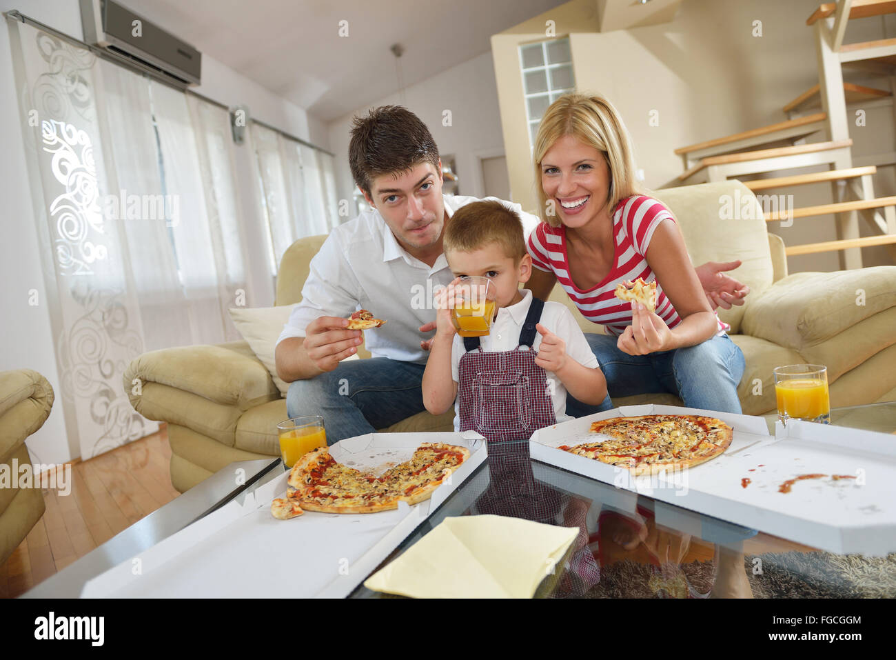 Famiglia mangiare la pizza Foto Stock