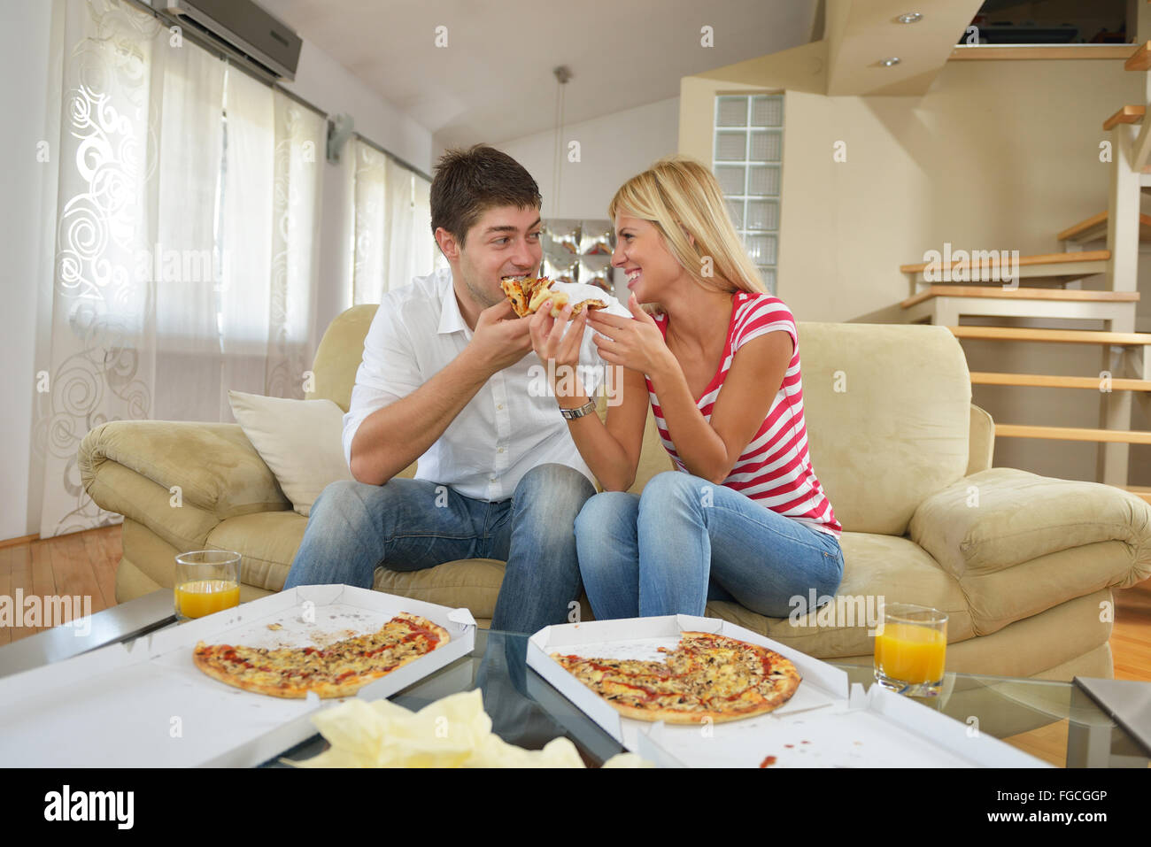 Giovane a casa a mangiare la pizza Foto Stock