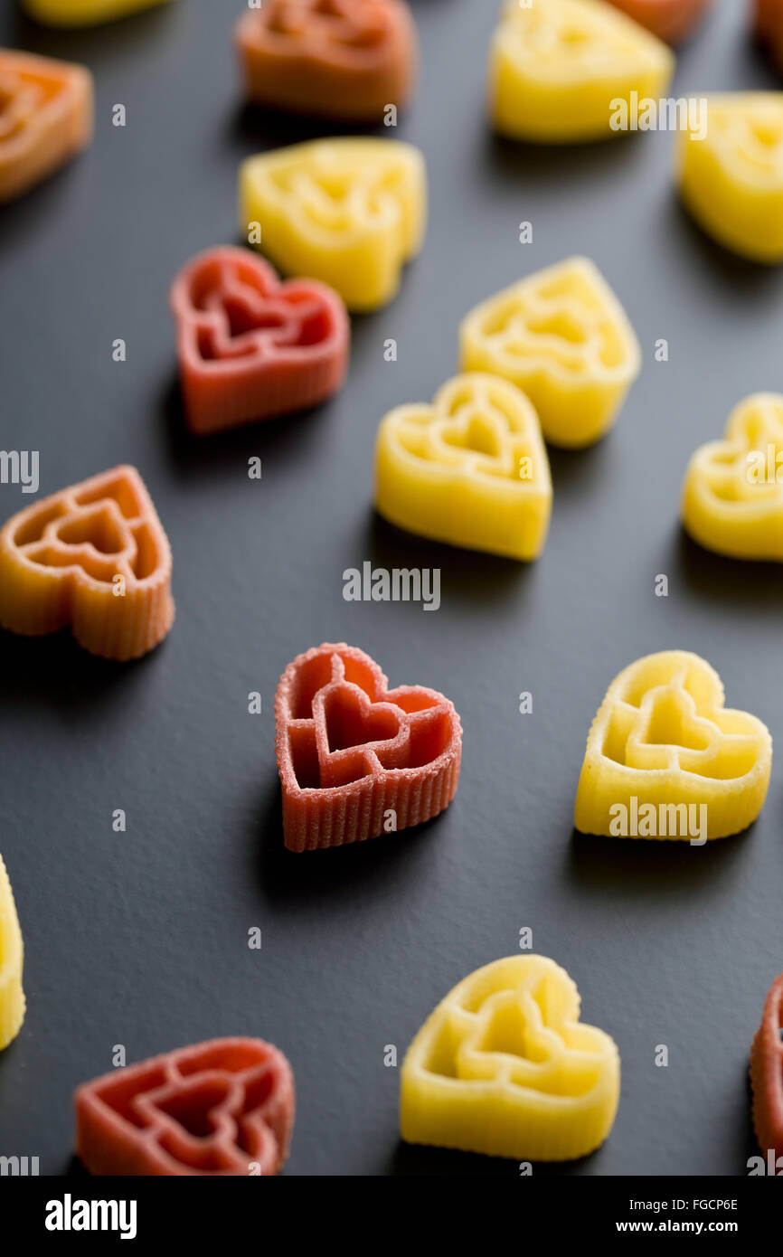 A forma di cuore la pasta su sfondo nero Foto stock - Alamy