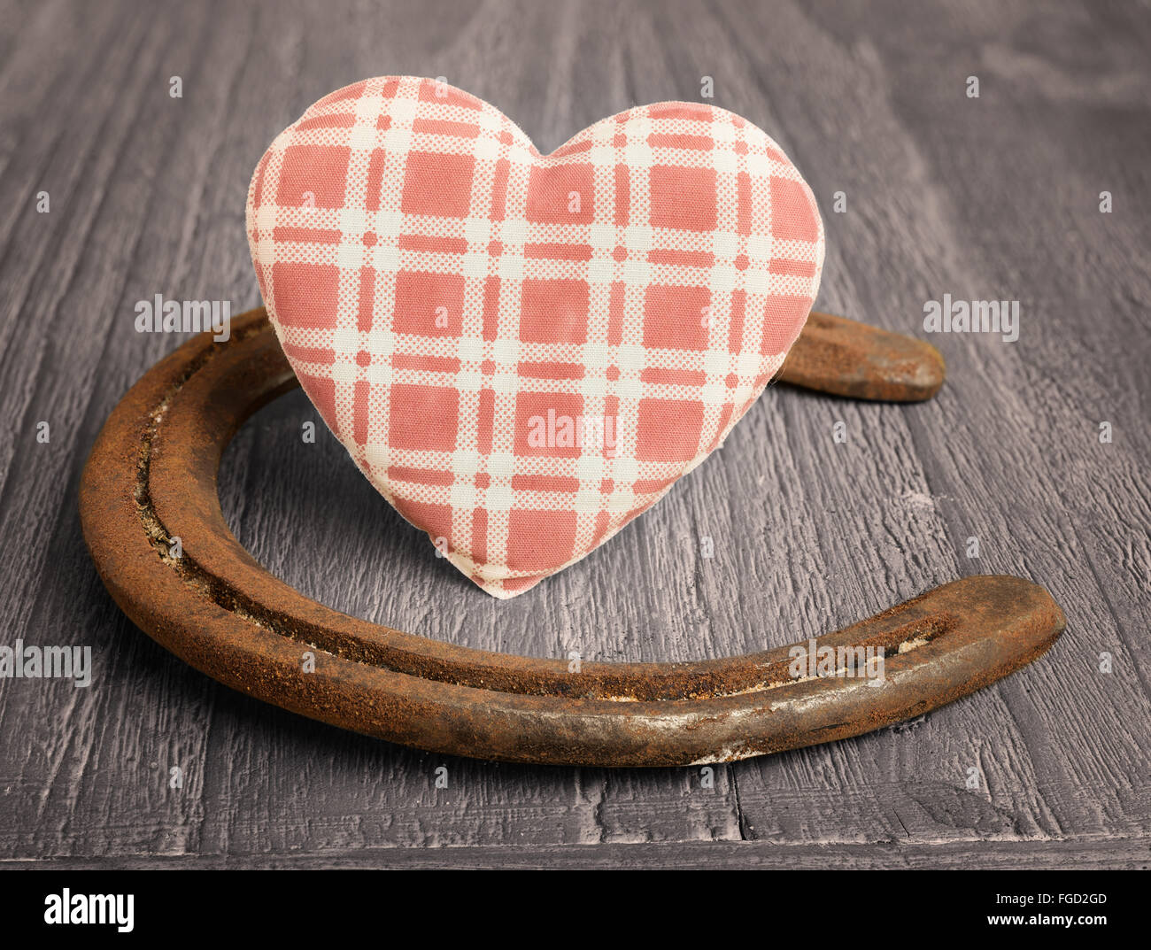 Tessuto retrò cuore e vecchi ferri di cavallo su sfondo di legno Foto Stock