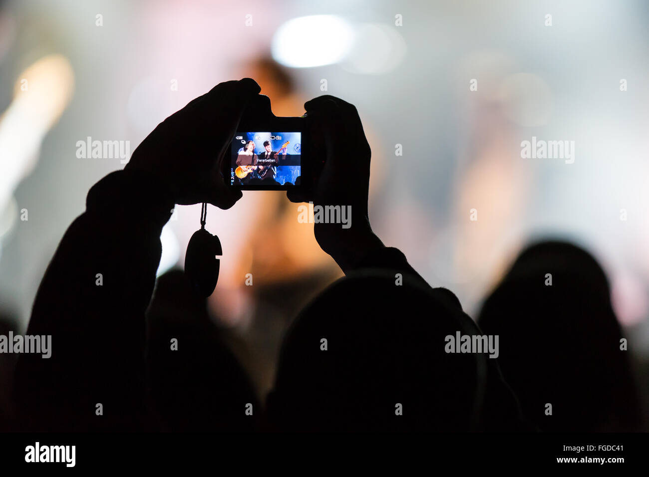 Concertgoers scatta una fotografia con iPhone Foto Stock