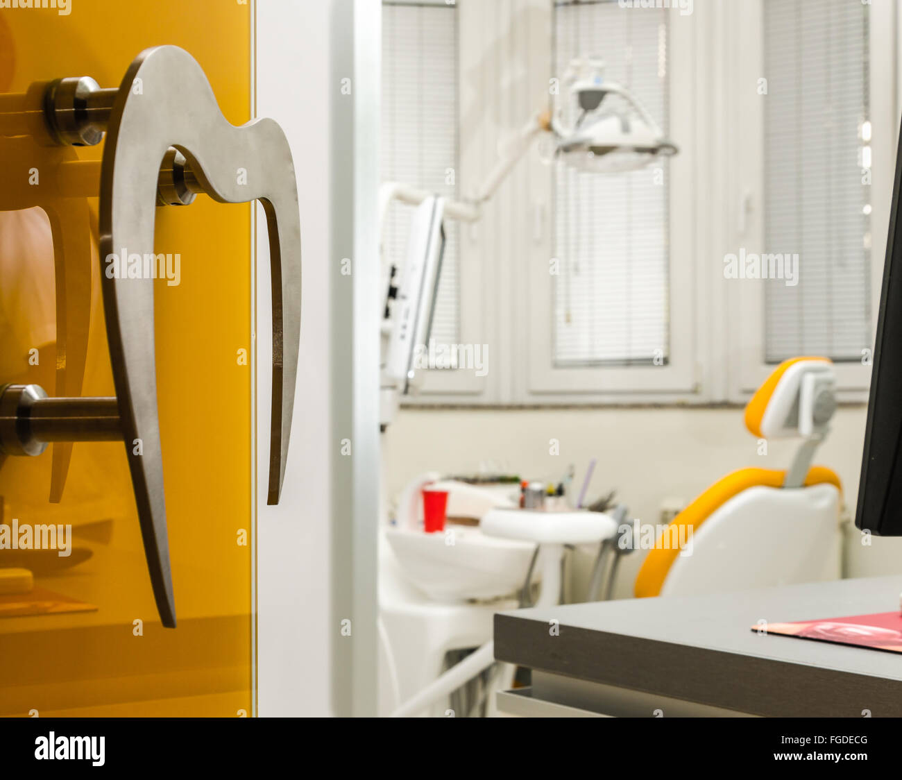 Studio dentista visto attraverso la porta aperta, con manico a forma di un dente. Foto Stock