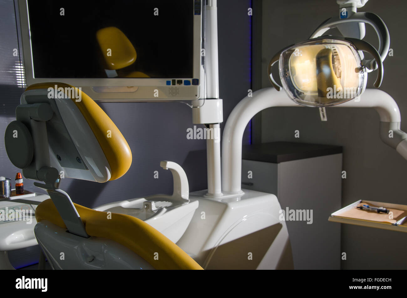 Studio dentista solo con la lampada accesa, nelle tenebre. Foto Stock