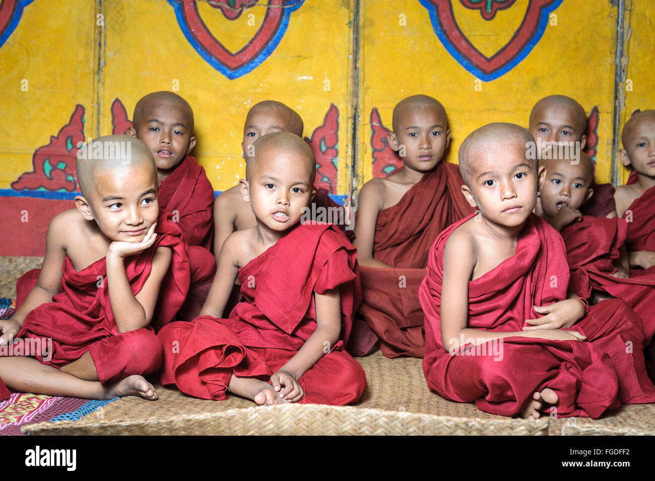Un gruppo di giovani ragazzi di colore rosso da indossare vesti buddhisti pronto a diventare novizie. Foto Stock