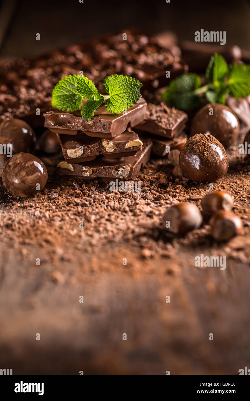 Pila assortiti di barrette di cioccolato su sfondo di legno Foto Stock