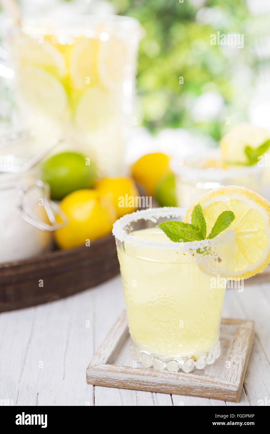 Rinfrescante limonata fatta in casa su un rustico tavolo esterno in condizioni di luce intensa. Foto Stock