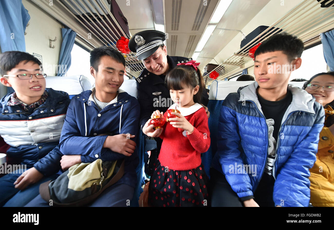 Taiyuan. 19 Feb, 2016. Un poliziotto presenta un regalo ad una ragazza sul treno da Taiyuan del nord della Cina nella provincia dello Shanxi a Chengdu del sud-ovest della Cina di provincia di Sichuan, Feb 19, 2016 per salutare la prossima festa delle lanterne. Credito: Cao Yang/Xinhua/Alamy Live News Foto Stock