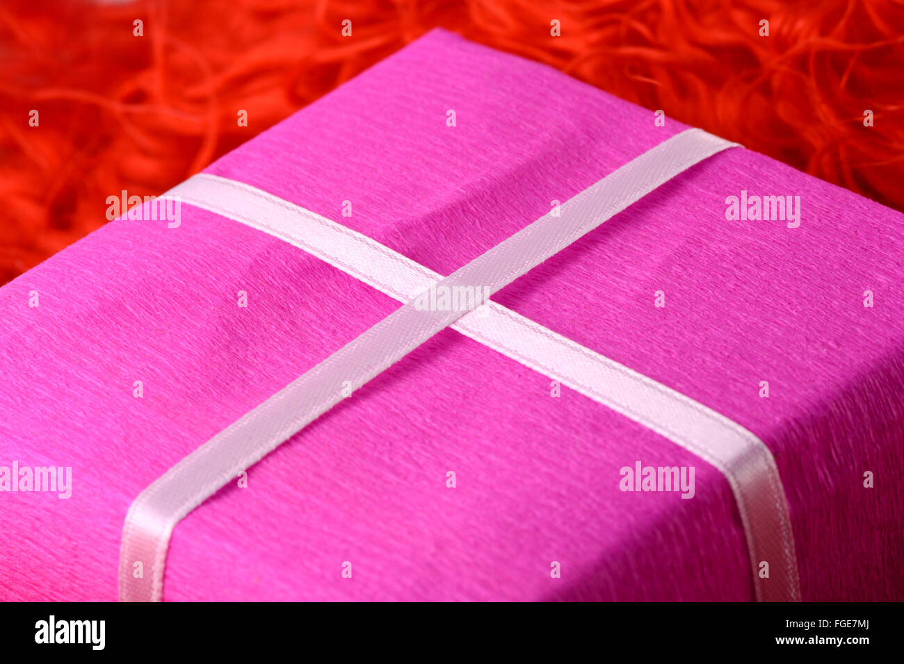 Confezione regalo con nastro bianco su sfondo rosso Foto Stock