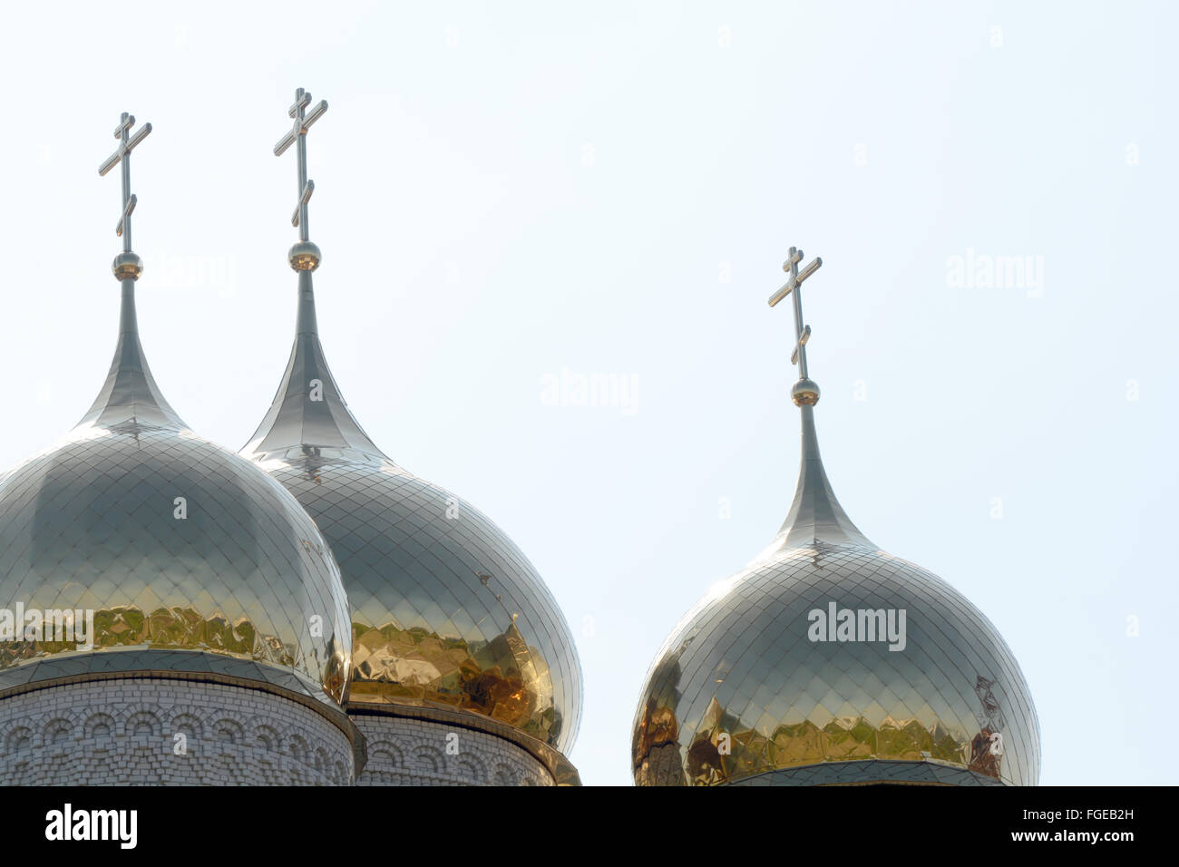 Cupola dorata e una croce cristiana sulla chiesa contro il cielo blu Foto Stock