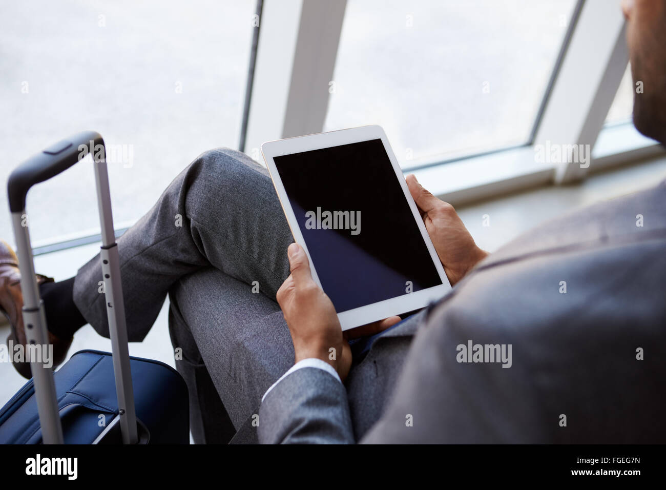 Imprenditore utilizzando digitale compressa In Airport Lounge di partenza Foto Stock