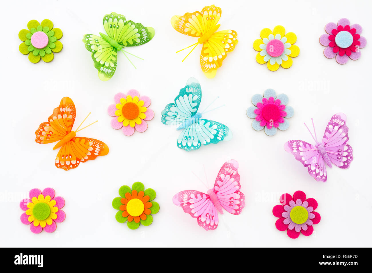 Una molla sullo sfondo di coloratissimi fiori fatti a mano e le farfalle. Un'arte ed artigianato e la visualizzazione di oggetti fatti in casa. Foto Stock