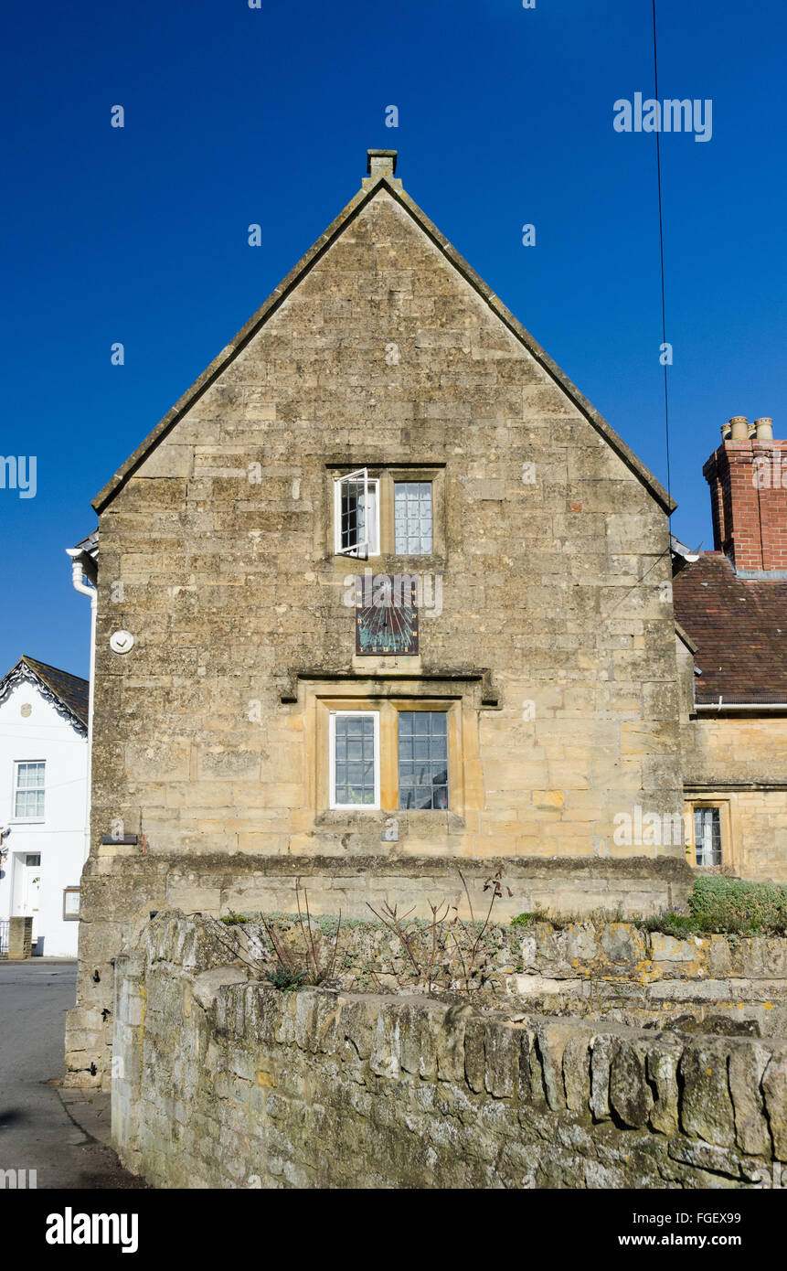 Lato del Cotswold vecchio edificio in pietra in Worcestershire con un orologio solare sulla parete Foto Stock
