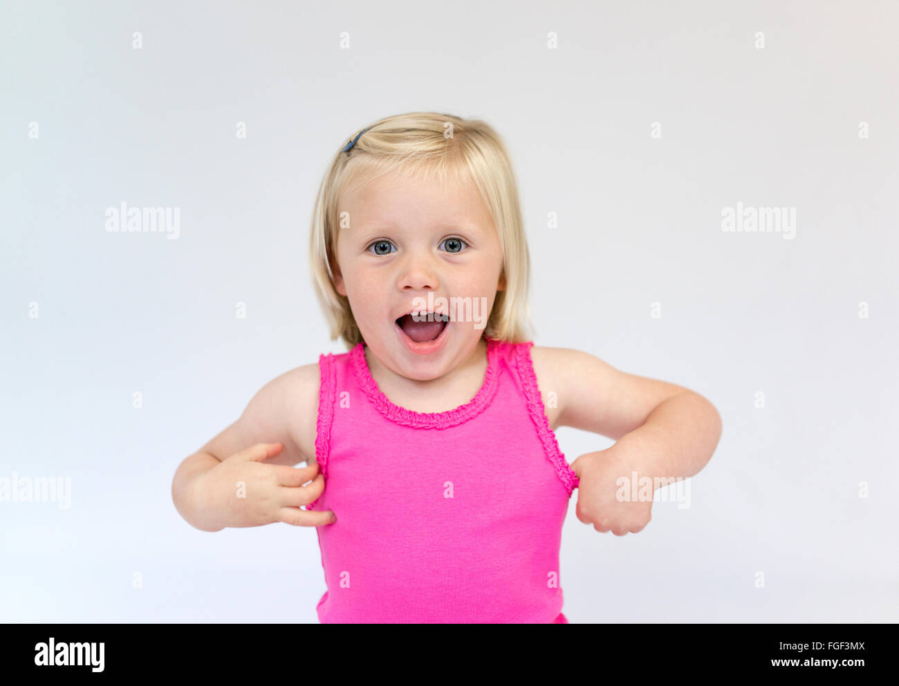 Ritratto di una giovane ragazza con corti capelli biondi che indossa un giubbotto rosa top ridere Foto Stock