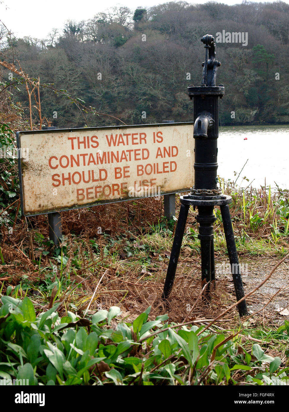 L'acqua contaminata segno accanto al pubblico acqua pompa a mano, Penpol, Falmouth, Cornwall, Regno Unito Foto Stock