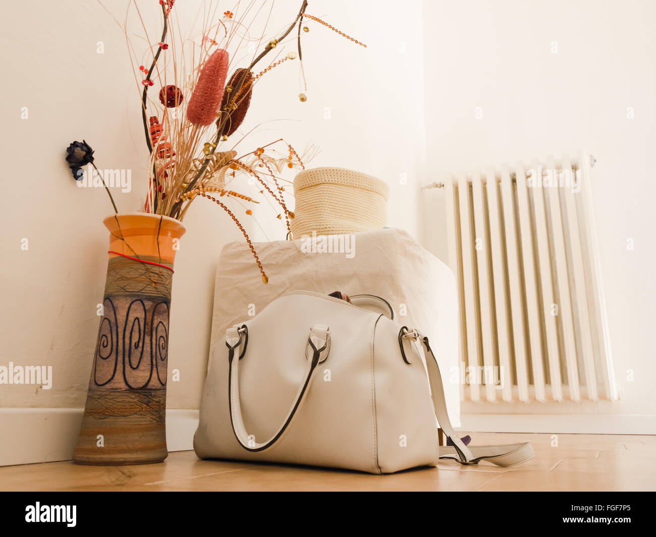 Still Life with vase , borsetta, pouf e riscaldatore. interiof di una casa. Foto Stock