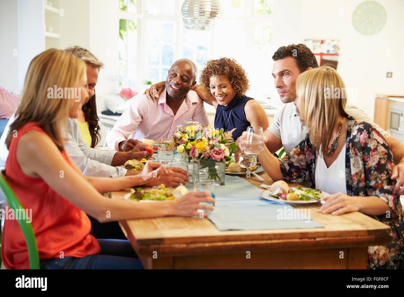 Coppia di amici seduti intorno al tavolo a cena Foto Stock