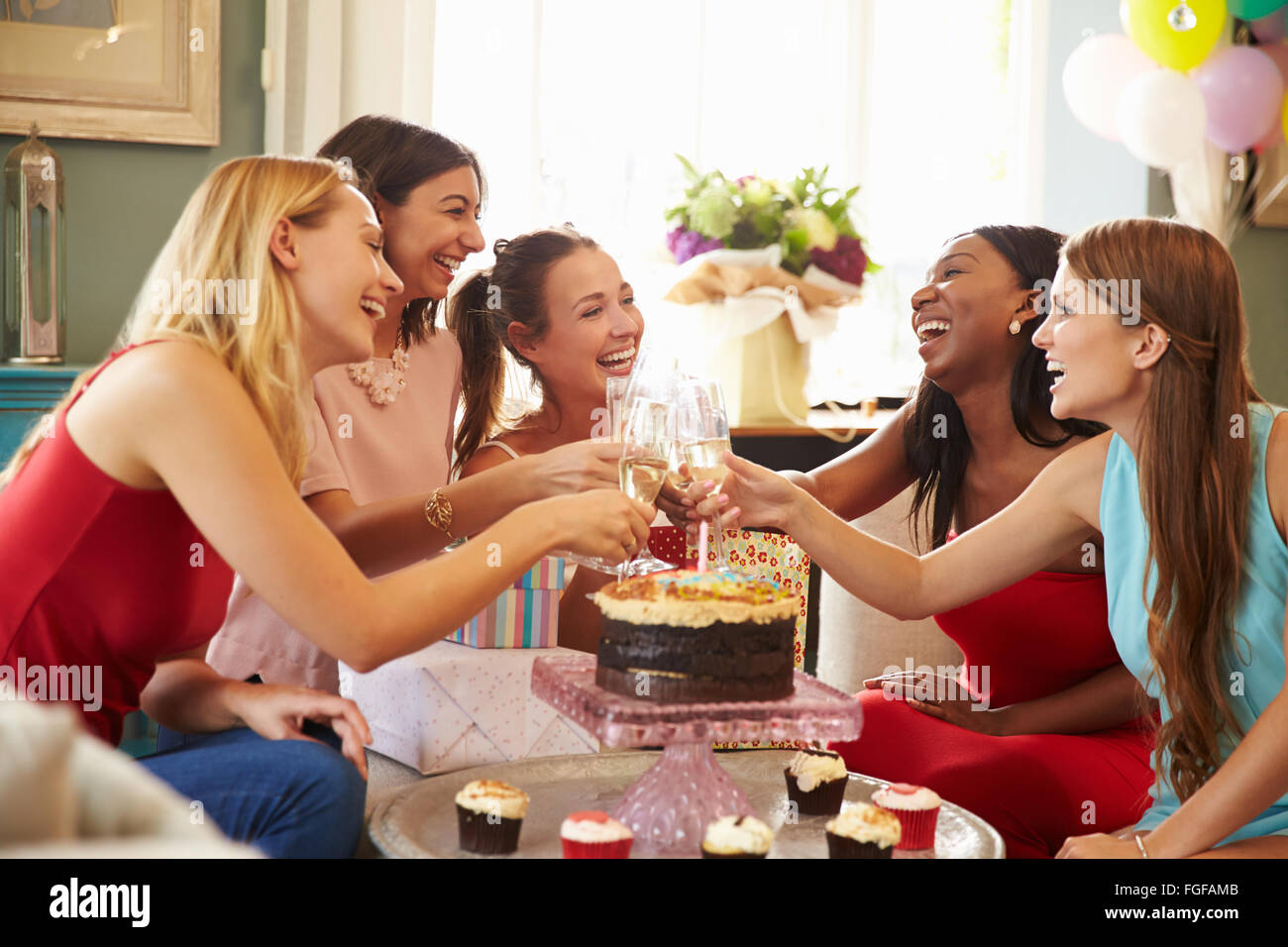 Amici di sesso femminile facendo un brindisi per festeggiare il compleanno Foto Stock