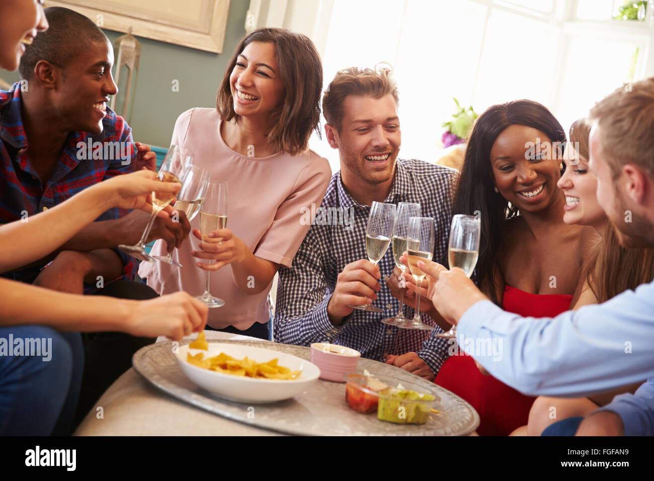 Gruppo di amici di festeggiare con un brindisi a casa Foto Stock