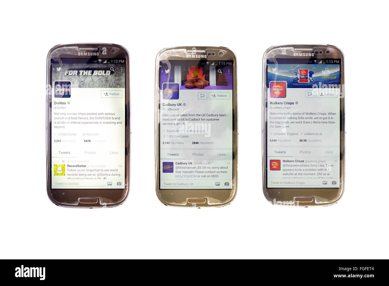 Il cioccolato e le patatine aziende account twitter su schermate dello smartphone fotografati contro uno sfondo bianco. Foto Stock