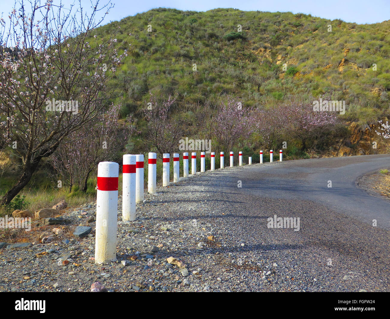 La curva con il bianco e il rosso paracarri stradali Foto Stock