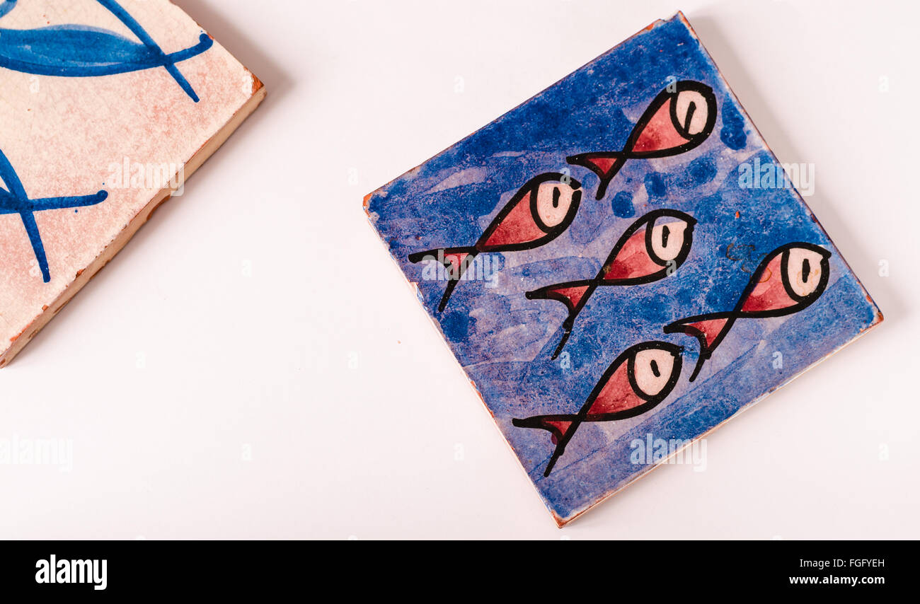 Piastrelle blu con un gruppo di cinque pesci rossi il disegno su di esso e un pezzo di una seconda tessera sulla sinistra. copia spazio sulla sinistra Foto Stock