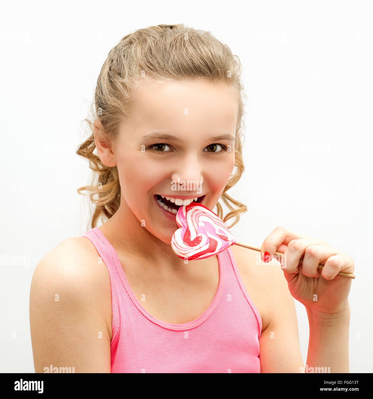 Ritratto di un felice ragazza giovane con la caramella a forma di cuore Foto Stock