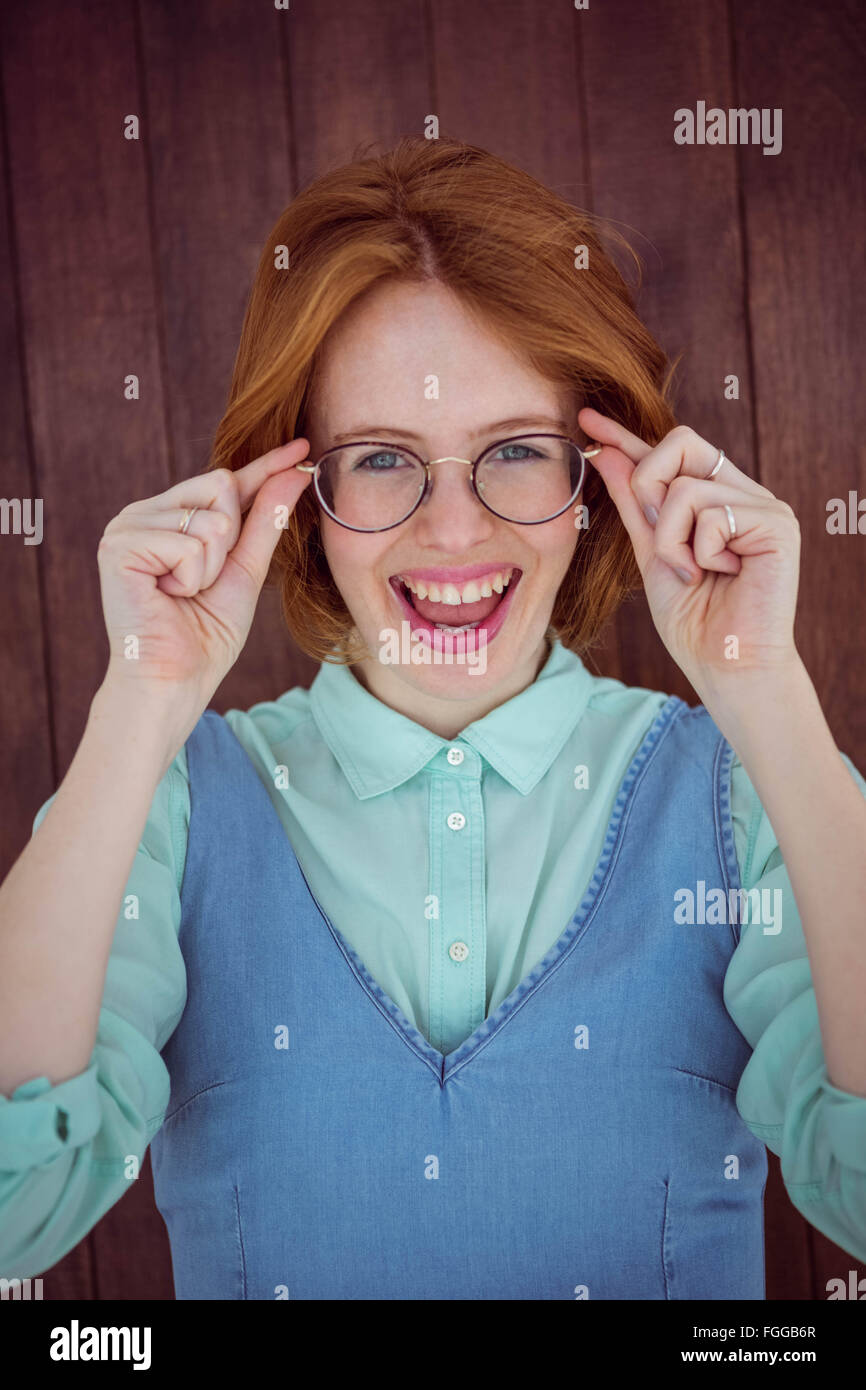 I capelli rossi hipster donna tenendo gli occhiali Foto Stock