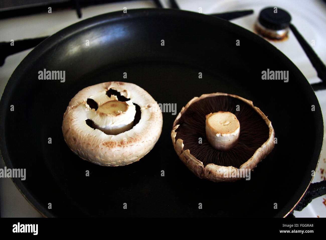 Due funghi in padella con un sorriso Foto Stock