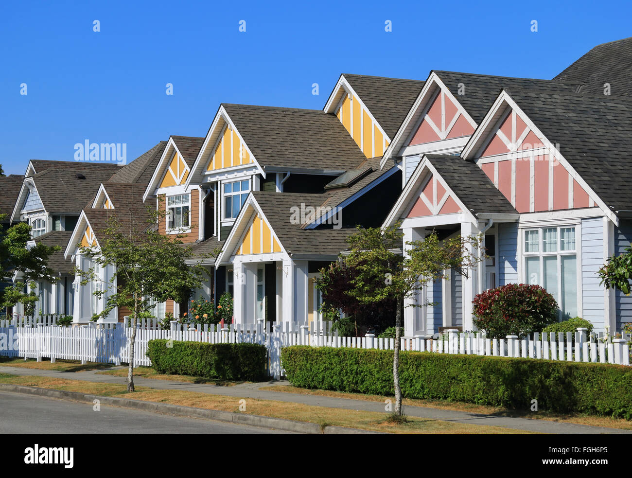 Una fila di un nuovo case in Richmond, British Columbia, Canada. Cantieri anteriore del case e strada con alberi e cespugli. Foto Stock