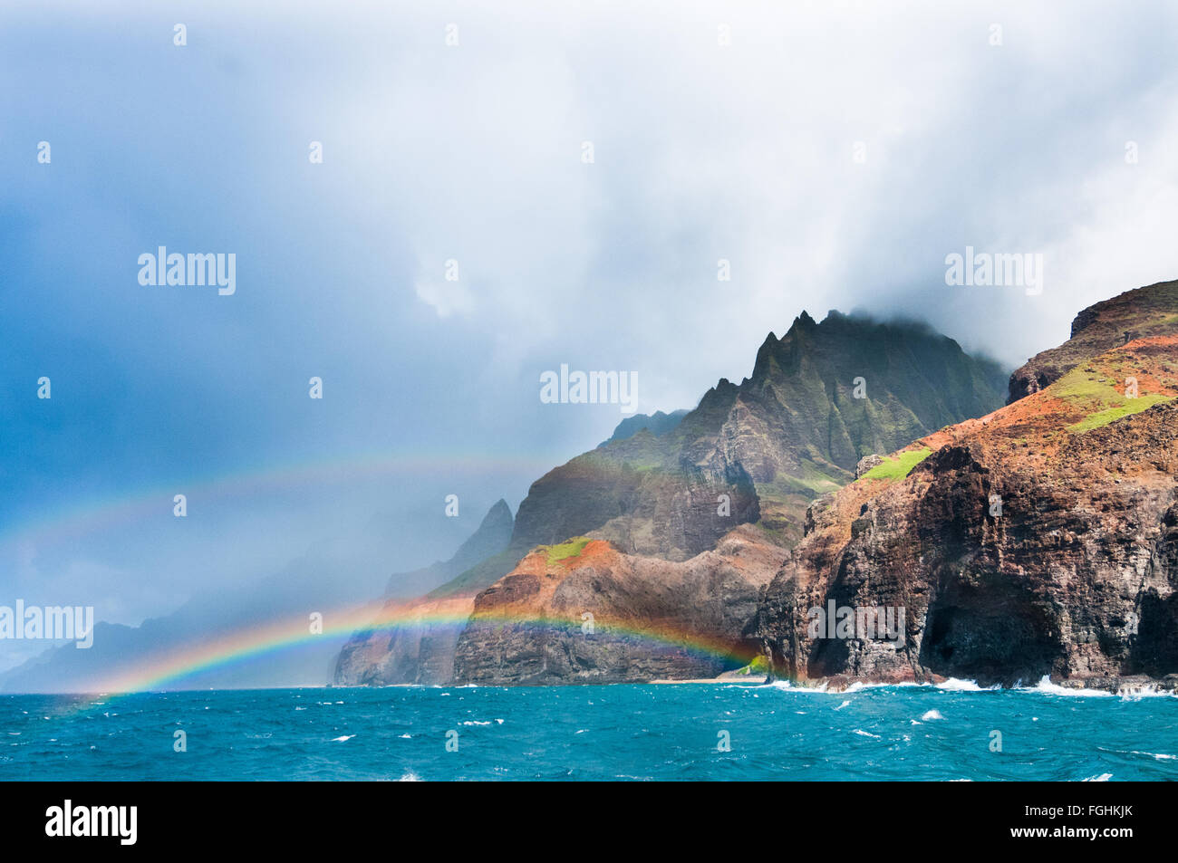 Livello del mare vista di un arcobaleno che appare al di sopra della Costa Na Pali in Kauai, Hawaii. Foto Stock