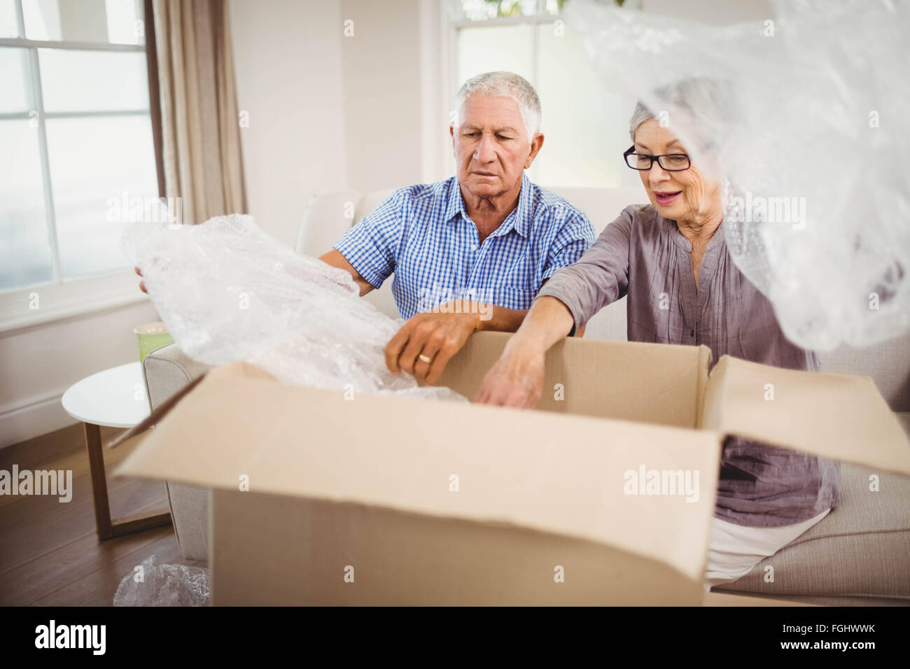 Coppia senior disimballaggio di una scatola di cartone Foto Stock