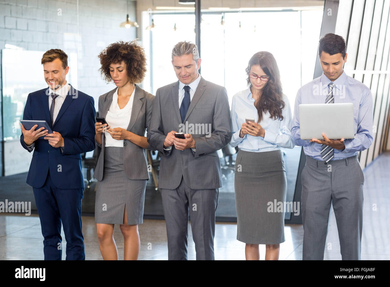 Gli imprenditori tramite telefono cellulare, lap top e tavoletta digitale Foto Stock
