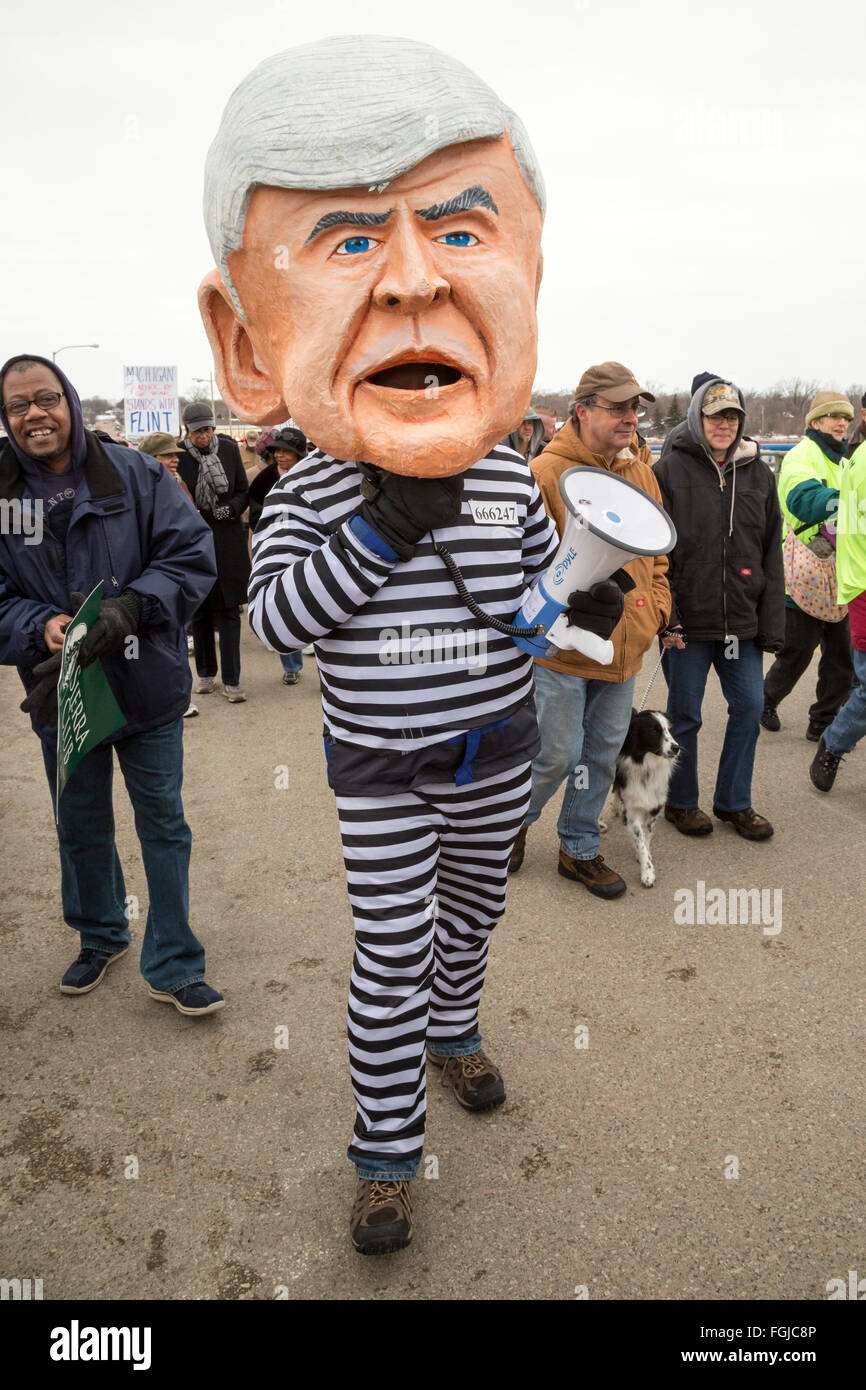 Selce, Michigan STATI UNITI D'America - 19 Febbraio 2016 - i residenti hanno marciato per la pietra focaia impianto di trattamento delle acque di esigere la ricostruzione della città infrastrutture idriche. Uno protester indossava una prigione uniforme e una maschera sovradimensionata del Michigan governatore Rick Snyder, chiamando per il governatore dell'arresto. Credito: Jim West/Alamy Live News Foto Stock