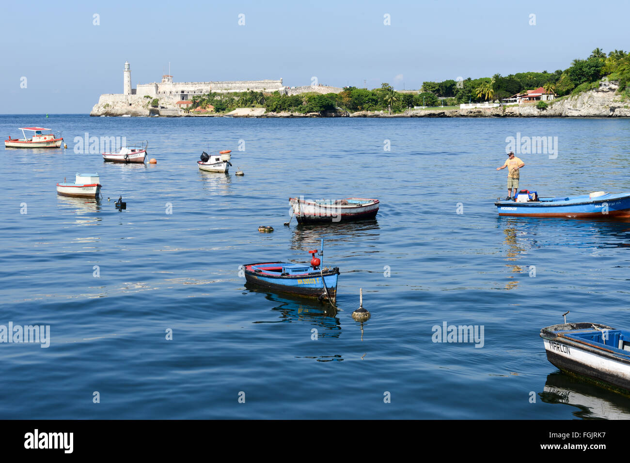 L'Avana il 7 gennaio 2016: pescatore sulla sua barca nella baia di l'Avana con El Morro castle in background Foto Stock