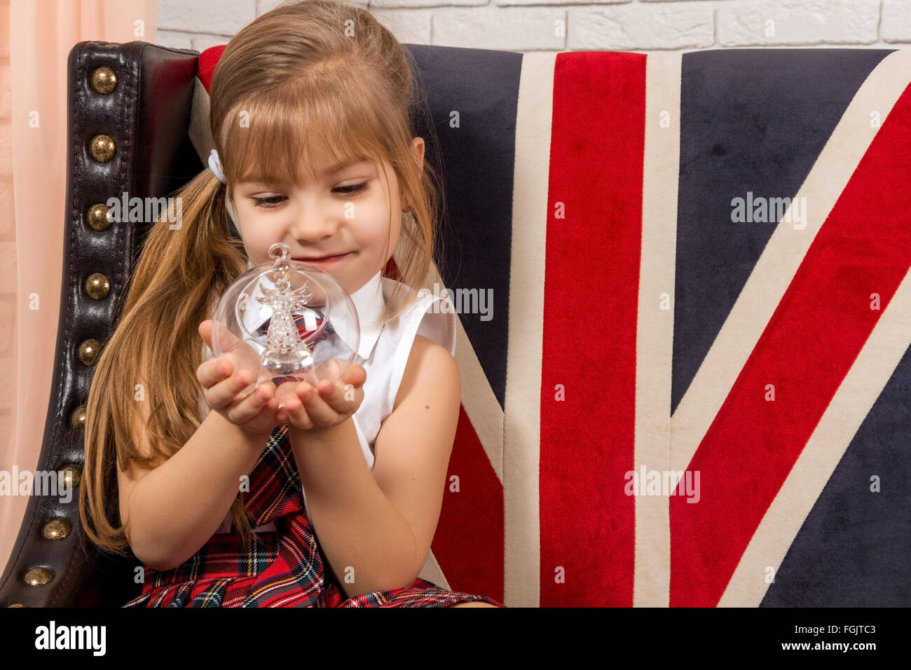 Ragazza seduta su una sedia con una bandiera britannica Foto Stock