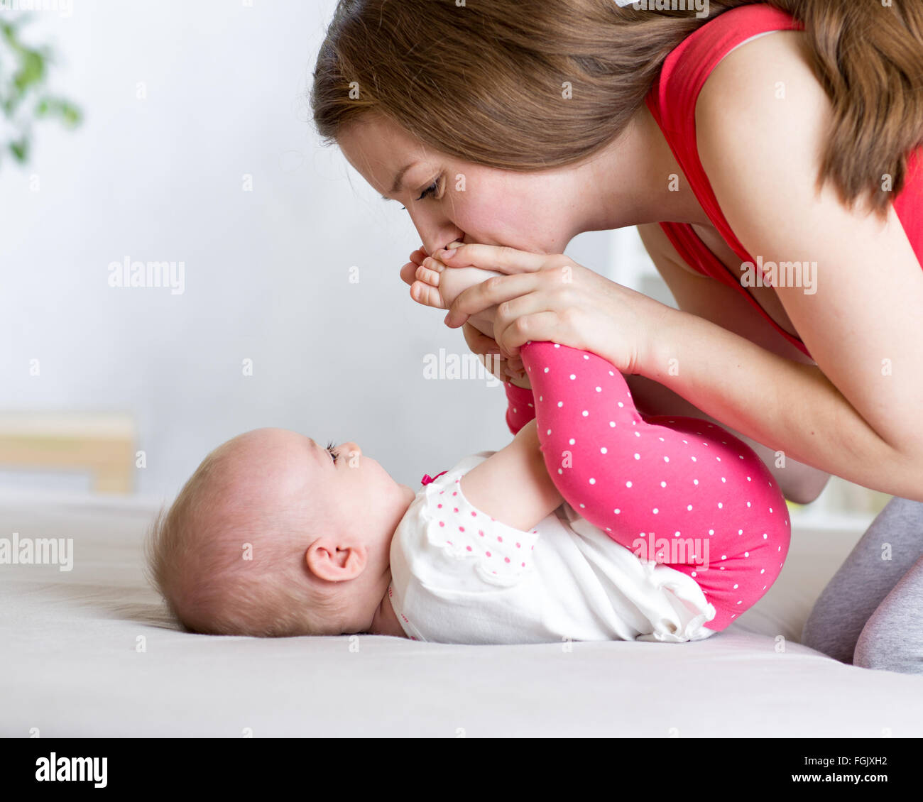 Mom gioiosa giocando con il suo bambino neonato Foto Stock
