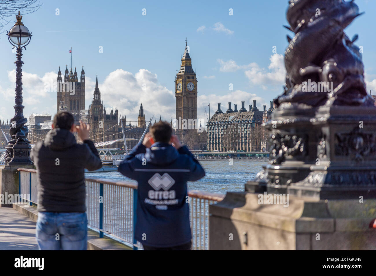 I turisti a scattare foto di Big Ben e le Camere del Parlamento attraverso il fiume Tamigi nella città di Londra Inghilterra REGNO UNITO Foto Stock