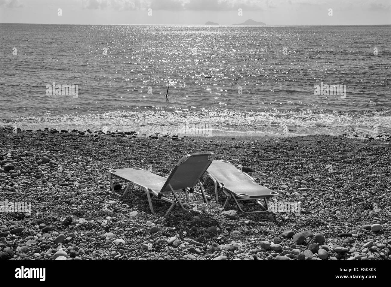Santorini - sun beths sulla spiaggia nera dalla parte sud dell'isola. Foto Stock
