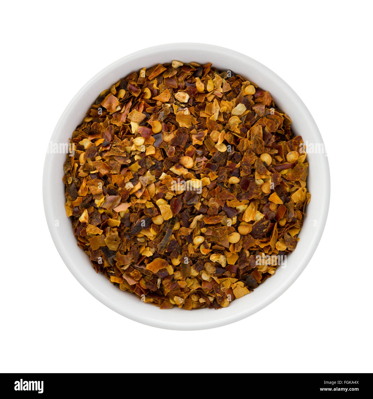 Peperoncino rosso tritato in un vaso di ceramica. L'immagine è tagliata, isolato su uno sfondo bianco. Foto Stock