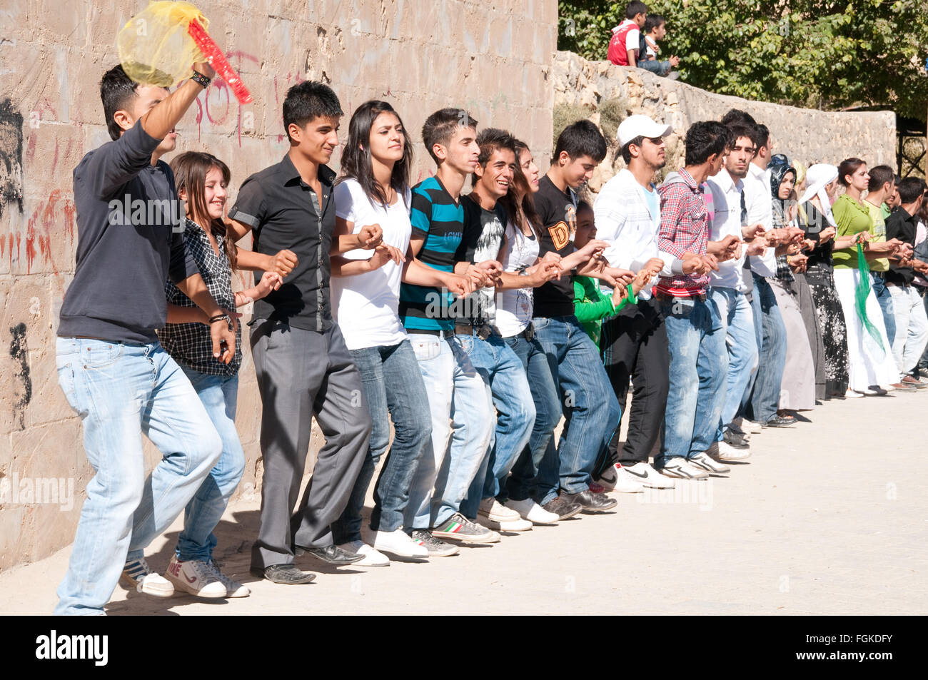 Giovani curdi agli uomini e alle donne di prendere parte in una danza tradizionale a un matrimonio nella città di Mardin, nel sud-est della Turchia. Foto Stock