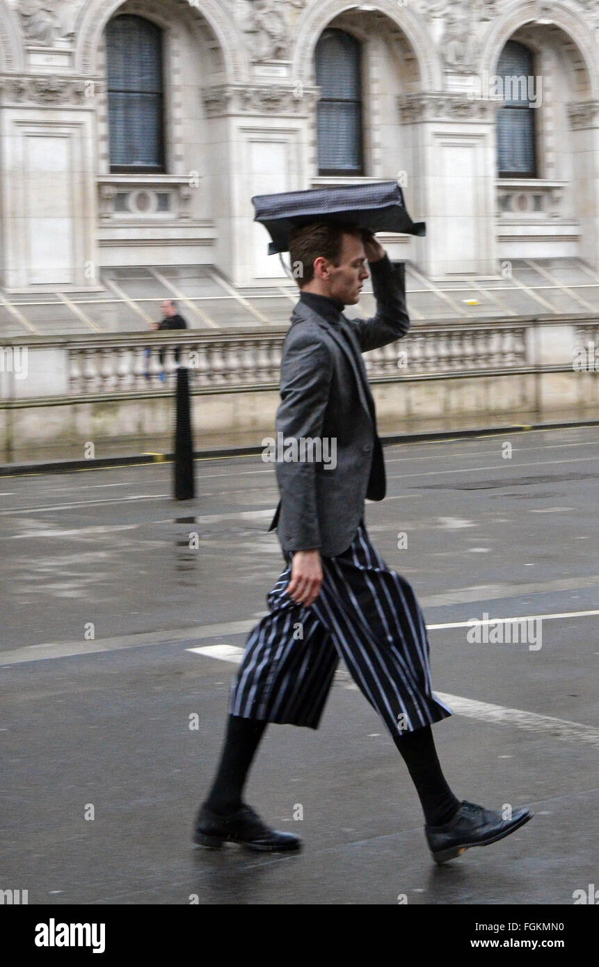 Londra, UK, 20 febbraio 2016, uomo attraversando Whitehall. Il vento e la pioggia a Londra come mini onda di calore previsto. Credito: JOHNNY ARMSTEAD/Alamy Live News Foto Stock