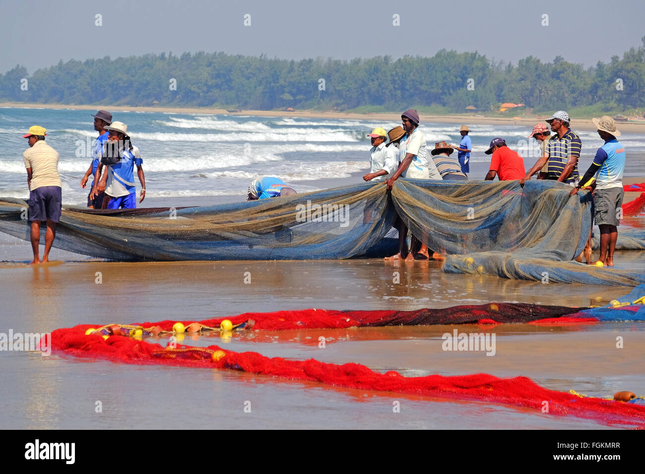 I pescatori reti da traino in su una spiaggia in Maharashtra, India del Sud  Foto stock - Alamy